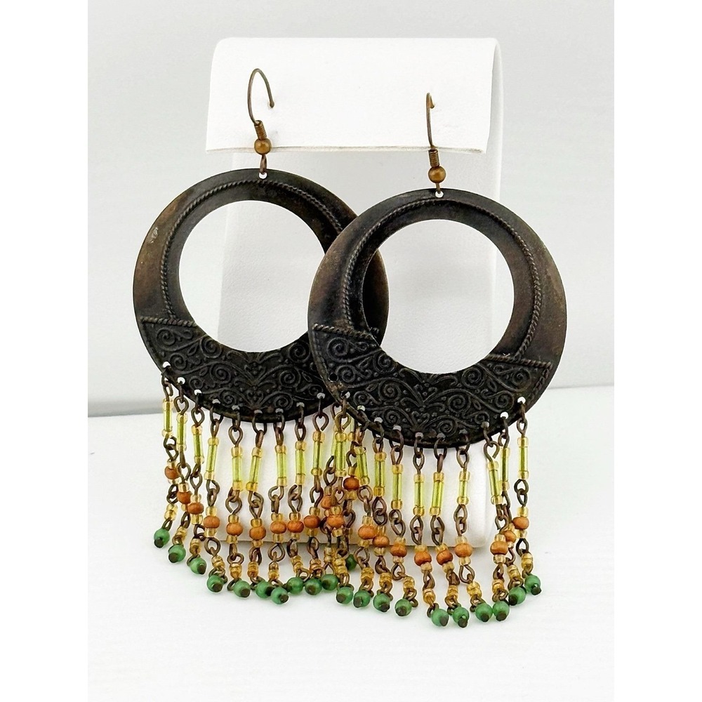 Metal designed circular earrings with dangly earth tone beads.